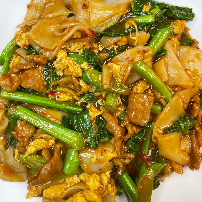 Close-up of Mr You Chinese Food's stir-fried noodles with beef, scrambled egg, and green vegetables.