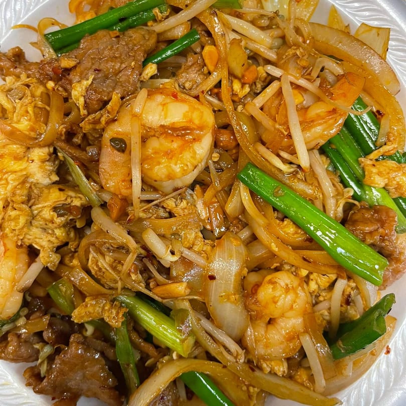 Close-up of Mr You Chinese Food's beef and shrimp chow fun with onions and scallions.